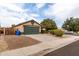 Tan house with a green garage door and street view at 15720 W Crocus Dr, Surprise, AZ 85379