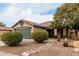 Tan house with a green garage door and stone pathway at 15720 W Crocus Dr, Surprise, AZ 85379