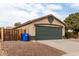 Tan house with a green garage door and wood fence at 15720 W Crocus Dr, Surprise, AZ 85379