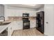 White kitchen with black appliances and tile flooring at 15720 W Crocus Dr, Surprise, AZ 85379