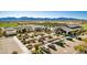 Aerial view of community clubhouse, pool, and parking lot with mountain backdrop at 17183 W San Marcos St, Surprise, AZ 85388