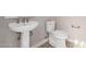 Clean bathroom with pedestal sink, toilet, and patterned floor at 17183 W San Marcos St, Surprise, AZ 85388