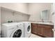 Laundry room with washer, dryer, and cabinets with granite countertops at 17183 W San Marcos St, Surprise, AZ 85388