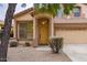 House entrance with yellow door, landscaping, and two-car garage at 17427 W Rock Wren Ct, Goodyear, AZ 85338