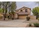 Two-story house with beige exterior, two-car garage, and landscaping at 17427 W Rock Wren Ct, Goodyear, AZ 85338