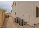 Home's side exterior showcasing a walkway, landscaping, and AC units at 17427 W Rock Wren Ct, Goodyear, AZ 85338