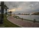 Scenic lakefront walkway with palm trees and lighting at 17427 W Rock Wren Ct, Goodyear, AZ 85338