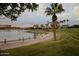 Scenic walking path alongside a lake with palm trees and beautiful landscaping at 17427 W Rock Wren Ct, Goodyear, AZ 85338