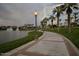 Curved walkway by a lake with palm trees and lighting at 17427 W Rock Wren Ct, Goodyear, AZ 85338