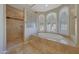 Bright bathroom with a tiled shower, soaking tub, and natural light from glass block and shuttered windows at 18009 W Denton Ave, Litchfield Park, AZ 85340