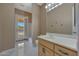 Bathroom with a light wood vanity, double doors leading to the pool, and a large mirror at 18009 W Denton Ave, Litchfield Park, AZ 85340