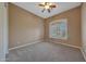 Empty bedroom featuring neutral carpet, a ceiling fan, and a bright window with shutters at 18009 W Denton Ave, Litchfield Park, AZ 85340