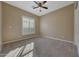 Neutral bedroom with carpet, ceiling fan, window with shutters, and tan walls at 18009 W Denton Ave, Litchfield Park, AZ 85340