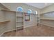 Spacious walk-in closet featuring custom shelving and ample hanging space with bright natural light at 18009 W Denton Ave, Litchfield Park, AZ 85340