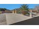 Long driveway leading to a three-car garage, complemented by desert landscaping and mature plants at 18009 W Denton Ave, Litchfield Park, AZ 85340