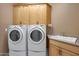 Laundry room with washer, dryer, cabinets, and utility sink at 18009 W Denton Ave, Litchfield Park, AZ 85340