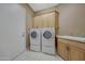 Laundry room featuring a washer, dryer, utility sink and built-in cabinets for storage at 18009 W Denton Ave, Litchfield Park, AZ 85340