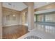 Bright living room featuring hardwood floors, columns, neutral colors, and an elegant light fixture at 18009 W Denton Ave, Litchfield Park, AZ 85340