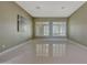 Bright living room with tile floors, neutral paint, and bright shutters on two windows at 18009 W Denton Ave, Litchfield Park, AZ 85340