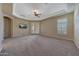 Large carpeted main bedroom featuring French doors and a ceiling fan with tray ceiling at 18009 W Denton Ave, Litchfield Park, AZ 85340