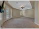 Large carpeted main bedroom with French doors, a ceiling fan, and a tray ceiling at 18009 W Denton Ave, Litchfield Park, AZ 85340