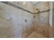 Walk-in shower showcasing stone accents, shower head and controls, and tiled walls and floors at 18009 W Denton Ave, Litchfield Park, AZ 85340