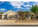 Tan two-car garage home with mature landscaping and a paved driveway at 18135 N Saddle Ridge Dr, Surprise, AZ 85374