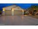 Two-car garage with palm trees and exterior lighting at 18135 N Saddle Ridge Dr, Surprise, AZ 85374