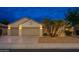 Two-car garage with palm trees and exterior lighting at 18135 N Saddle Ridge Dr, Surprise, AZ 85374