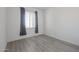 Bright bedroom with gray curtains and wood-look flooring at 18171 W Glenhaven Dr, Goodyear, AZ 85338