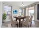 Bright dining room with wooden table, neutral chairs, and sliding door to backyard at 18171 W Glenhaven Dr, Goodyear, AZ 85338