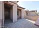 Covered entryway with a brick paved patio and brown door at 18171 W Glenhaven Dr, Goodyear, AZ 85338