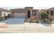 Front view of a house with a two-car garage and drought-tolerant landscaping at 18171 W Glenhaven Dr, Goodyear, AZ 85338