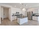 Modern kitchen with white cabinets, granite island, and stainless steel appliances at 18171 W Glenhaven Dr, Goodyear, AZ 85338