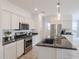 Modern kitchen with white cabinets, granite countertops, and stainless steel appliances at 18171 W Glenhaven Dr, Goodyear, AZ 85338