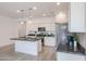 Modern kitchen with white cabinets, granite island, and stainless steel appliances at 18171 W Glenhaven Dr, Goodyear, AZ 85338