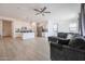 Open floor plan with kitchen island, stainless steel appliances, and living room with gray sectional sofa at 18171 W Glenhaven Dr, Goodyear, AZ 85338