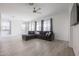 Spacious living room with L-shaped sofa and ceiling fan at 18171 W Glenhaven Dr, Goodyear, AZ 85338