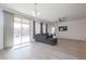 Living room with gray sectional sofa and sliding glass door to backyard at 18171 W Glenhaven Dr, Goodyear, AZ 85338