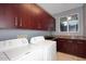 Laundry room with dark wood cabinets, granite counters, and new appliances at 18258 N 15Th Pl, Phoenix, AZ 85022