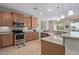 Modern kitchen with stainless steel appliances and wood cabinets at 21532 N 262Nd Ln, Buckeye, AZ 85396