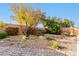 Landscaped backyard with trees, rock features, and pathway at 22708 N Kennedy Dr, Maricopa, AZ 85138