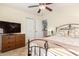 Charming bedroom with a ceiling fan, dresser, and an ensuite bathroom at 22708 N Kennedy Dr, Maricopa, AZ 85138