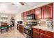 Well-equipped kitchen featuring dark wood cabinets, granite countertops, and modern appliances at 22708 N Kennedy Dr, Maricopa, AZ 85138