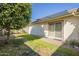 Back exterior view with a patio, grassy area, and a large orange tree at 2911 W Lamar Rd, Phoenix, AZ 85017