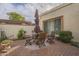 Brick patio with wooden table and chairs, umbrella, and shrubs at 2911 W Lamar Rd, Phoenix, AZ 85017