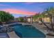 Inviting pool at sunset with a rock waterfall feature at 3165 E Indigo Bay Dr, Gilbert, AZ 85234