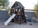 Wooden playset with slide, swings, and climbing features in the backyard at 3216 W Melody Dr, Laveen, AZ 85339