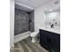 Modern bathroom with gray tile shower and dark vanity at 3447 W Dailey St, Phoenix, AZ 85053