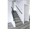 Modern staircase with gray wood-look flooring and black railing at 3447 W Dailey St, Phoenix, AZ 85053